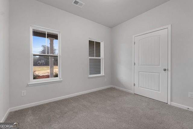 empty room with visible vents, baseboards, and carpet floors