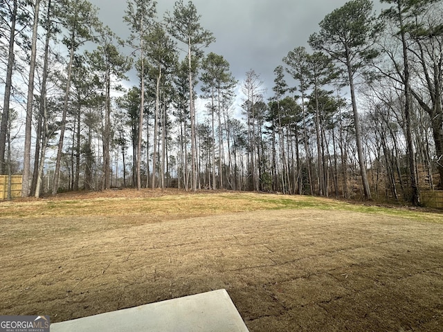 view of yard with a view of trees and fence
