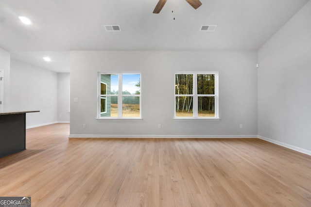 unfurnished living room with baseboards, a ceiling fan, light wood-type flooring, and visible vents