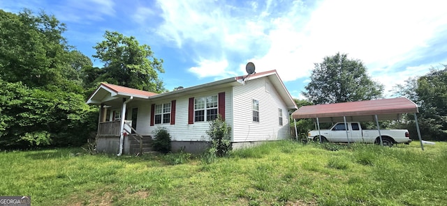 view of side of home featuring covered porch, crawl space, metal roof, and a carport
