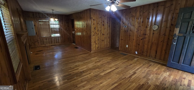 unfurnished dining area featuring wooden walls and hardwood / wood-style flooring