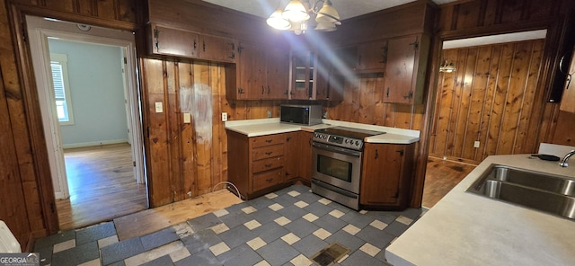 kitchen with a sink, electric range, black microwave, and light countertops