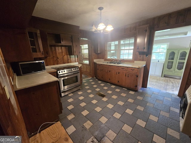 kitchen with a sink, a chandelier, stainless steel electric stove, and light countertops