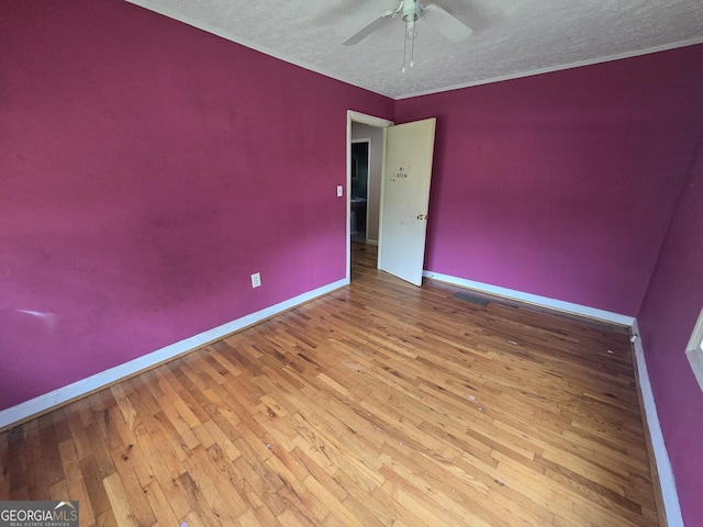 empty room featuring baseboards, ceiling fan, hardwood / wood-style flooring, and a textured ceiling