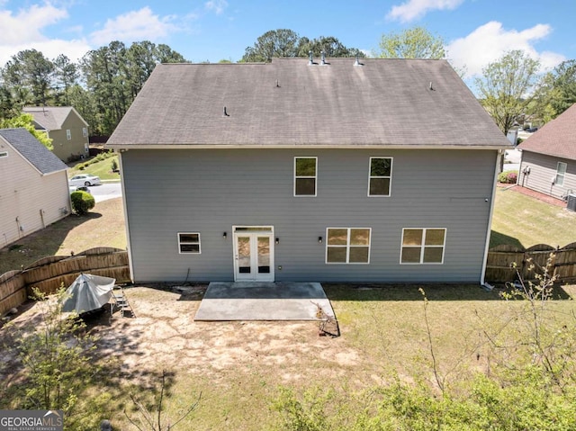 back of property featuring french doors, a patio, a lawn, and a fenced backyard
