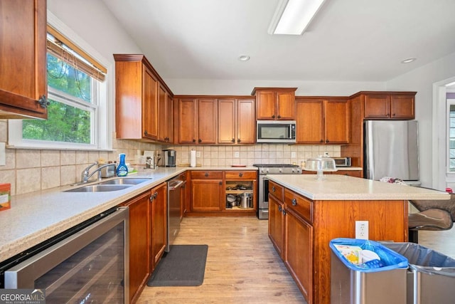 kitchen featuring decorative backsplash, a sink, light wood finished floors, wine cooler, and stainless steel appliances
