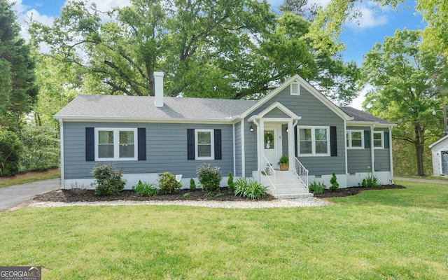 view of front of property with roof with shingles, a chimney, crawl space, and a front yard