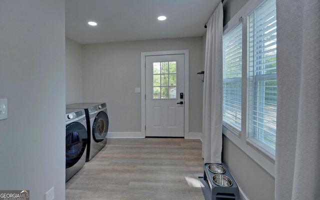 laundry area featuring washing machine and clothes dryer, recessed lighting, laundry area, and wood finished floors