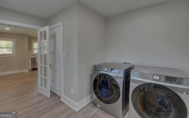 laundry room with laundry area, baseboards, washing machine and clothes dryer, french doors, and light wood finished floors