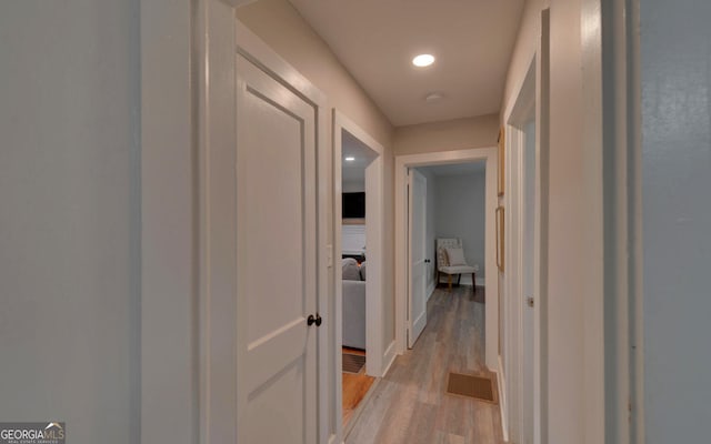 hallway featuring recessed lighting, baseboards, visible vents, and light wood-style flooring