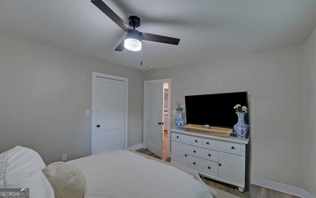 bedroom with a ceiling fan, baseboards, and wood finished floors