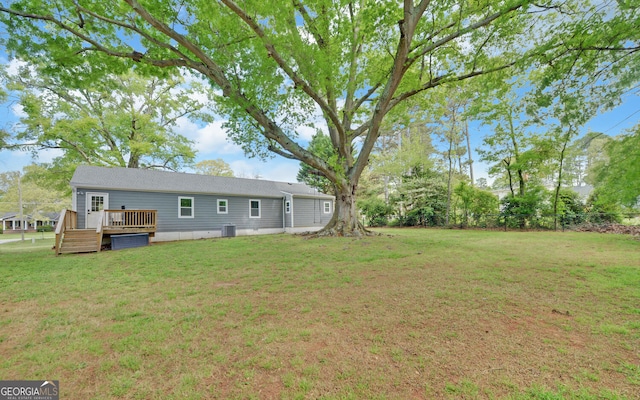 view of yard featuring central AC unit and a deck