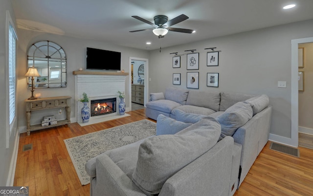 living area with a fireplace, a ceiling fan, recessed lighting, and visible vents