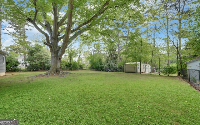 view of yard with a fenced backyard, an outdoor structure, and a shed