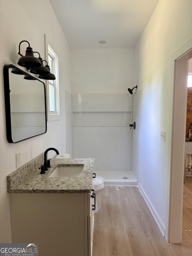 808 Center St, Macon, GA 31217 - bathroom featuring wood finished floors, vanity, a stall shower, and baseboards