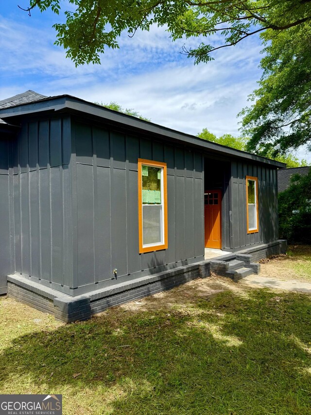 808 Center St, Macon, GA 31217 - view of home's exterior with board and batten siding, entry steps, and a yard