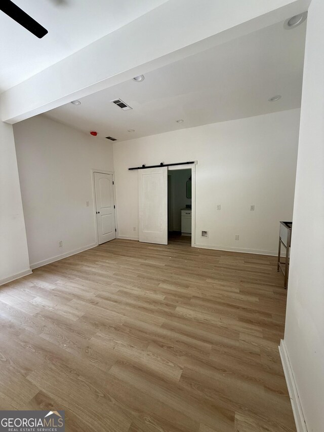 808 Center St, Macon, GA 31217 - spare room featuring light wood-style flooring, a barn door, and baseboards