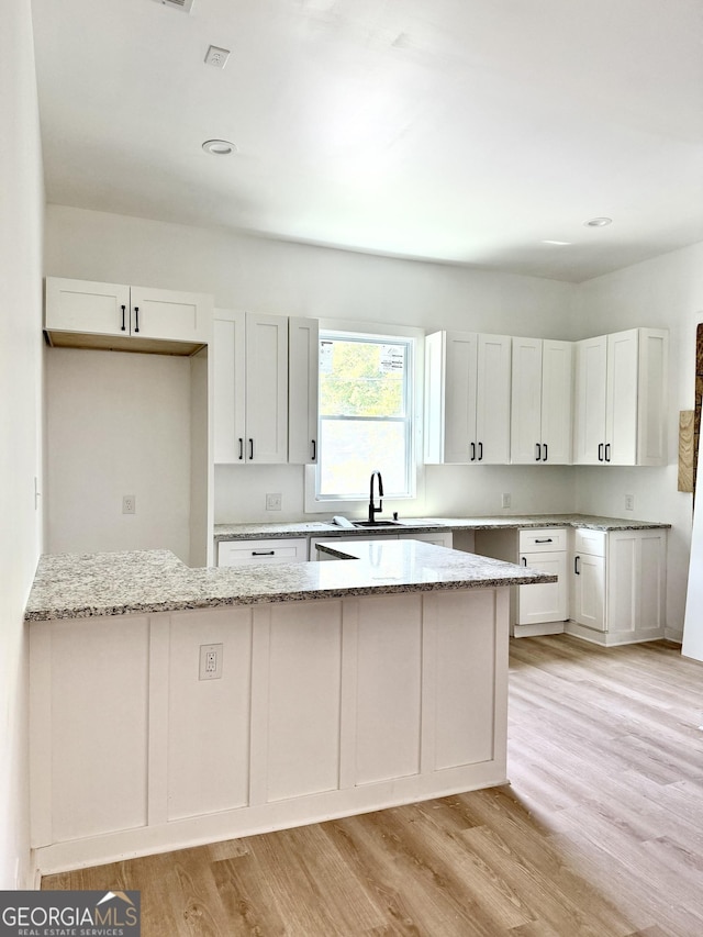 808 Center St, Macon, GA 31217 - kitchen featuring light stone counters, light wood-style floors, white cabinetry, a sink, and recessed lighting