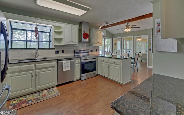 119 Ridgemore Cir, Toccoa, GA 30577 - kitchen with stainless steel appliances, wall chimney exhaust hood, a peninsula, lofted ceiling, and backsplash