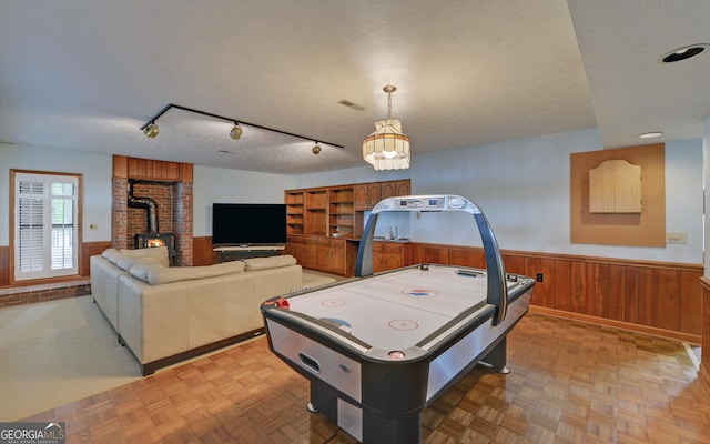 119 Ridgemore Cir, Toccoa, GA 30577 - recreation room with a wood stove, wainscoting, a textured ceiling, and wooden walls