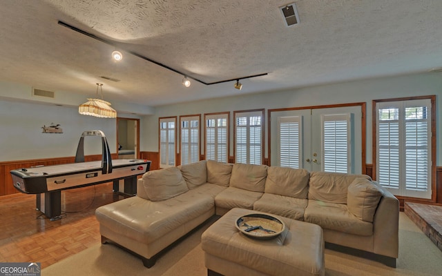 119 Ridgemore Cir, Toccoa, GA 30577 - living area with healthy amount of natural light, wainscoting, a textured ceiling, track lighting, and wood walls