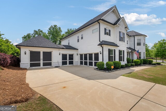 721 Paint Horse Dr, Canton, GA 30115 - rear view of property featuring driveway, a shingled roof, french doors, and an attached garage