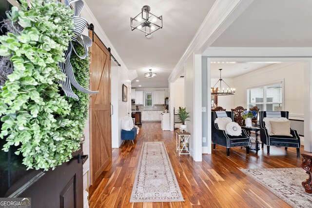 721 Paint Horse Dr, Canton, GA 30115 - foyer with crown molding, dark wood-type flooring, a barn door, and a chandelier
