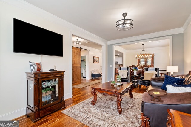 721 Paint Horse Dr, Canton, GA 30115 - living area with wood finished floors, crown molding, a barn door, a chandelier, and baseboards