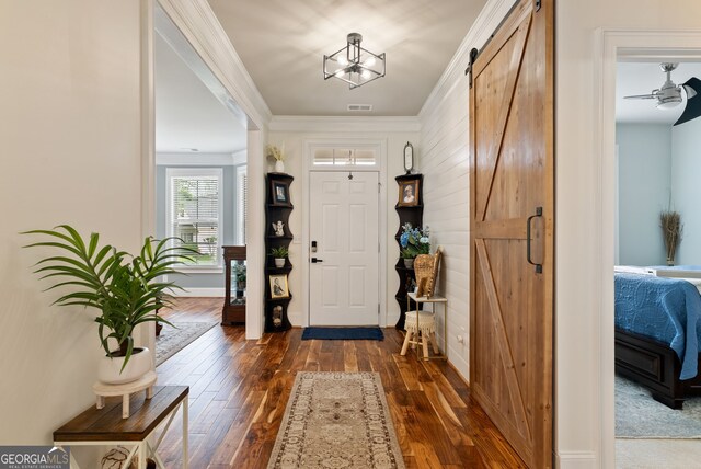 721 Paint Horse Dr, Canton, GA 30115 - entrance foyer featuring a barn door, dark wood-type flooring, baseboards, ornamental molding, and ceiling fan