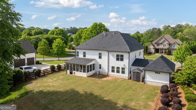 721 Paint Horse Dr, Canton, GA 30115 - rear view of property featuring a sunroom, a shed, an outdoor structure, roof with shingles, and a garage