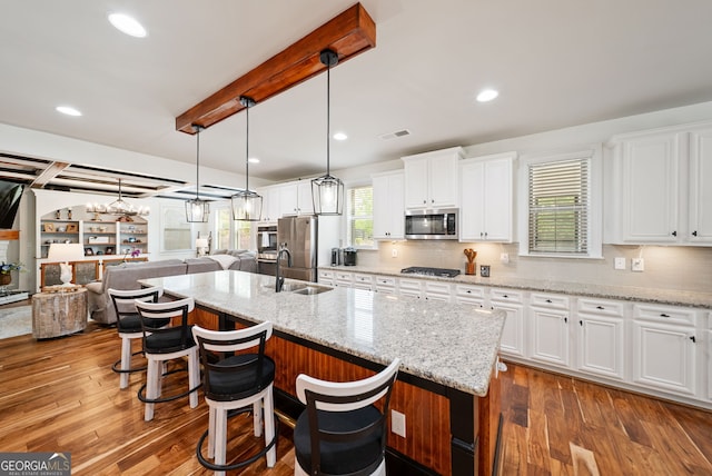 721 Paint Horse Dr, Canton, GA 30115 - kitchen with appliances with stainless steel finishes, beam ceiling, a sink, a kitchen island with sink, and open floor plan