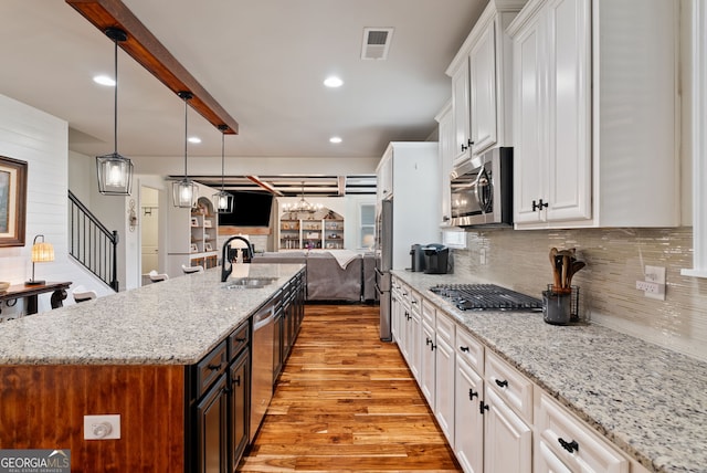 721 Paint Horse Dr, Canton, GA 30115 - kitchen featuring appliances with stainless steel finishes, a sink, open floor plan, white cabinetry, and light wood-type flooring