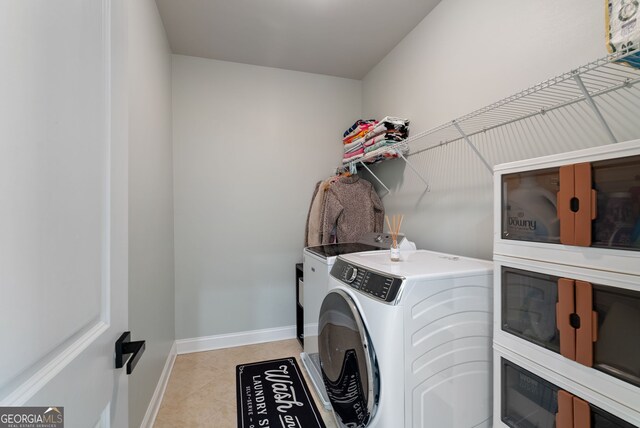 721 Paint Horse Dr, Canton, GA 30115 - clothes washing area featuring baseboards, washing machine and clothes dryer, and light tile patterned floors