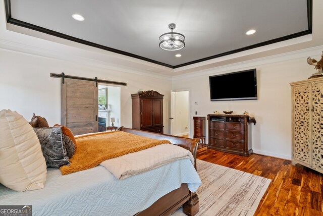 721 Paint Horse Dr, Canton, GA 30115 - bedroom featuring ornamental molding, a tray ceiling, a barn door, wood finished floors, and recessed lighting