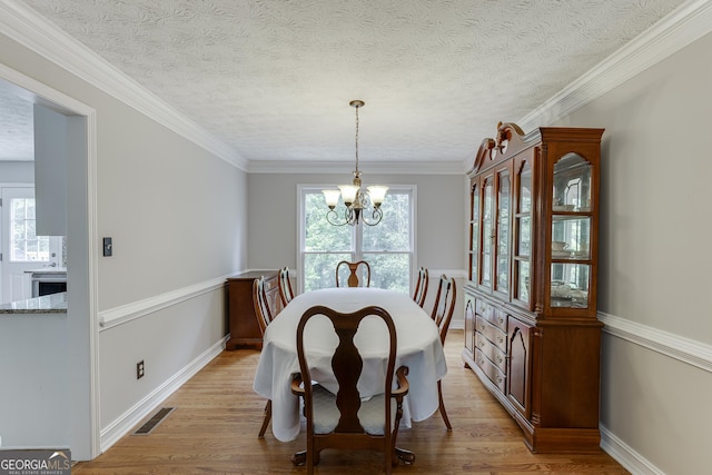 5922 Terrace Lake Pt, Flowery Branch, GA 30542 - dining area with a chandelier, light wood-style floors, a textured ceiling, and crown molding