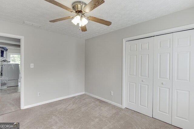 5922 Terrace Lake Pt, Flowery Branch, GA 30542 - unfurnished bedroom featuring carpet, a textured ceiling, a closet, washer and clothes dryer, and ceiling fan
