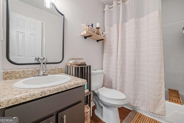 full bath featuring vanity, toilet, wood finished floors, and shower / tub combo with curtain