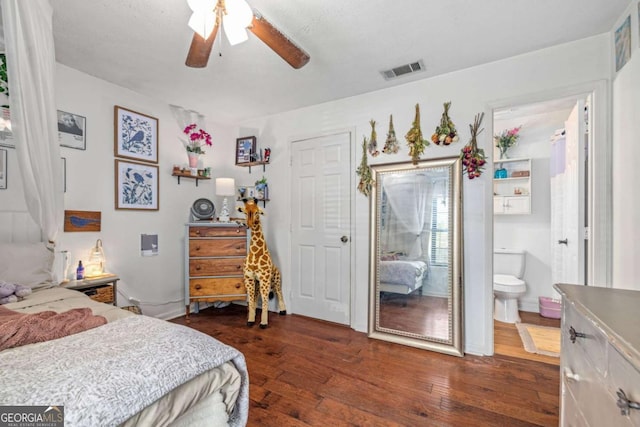 bedroom featuring ceiling fan, dark wood-style floors, ensuite bath, and visible vents