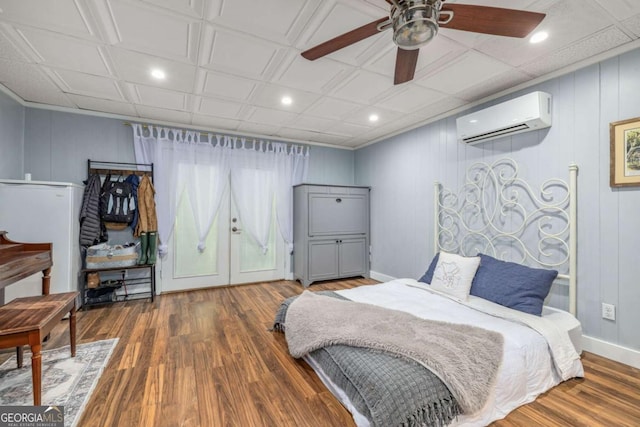 bedroom with a ceiling fan, wood finished floors, an AC wall unit, a decorative wall, and recessed lighting