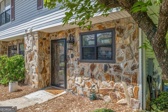 doorway to property with stone siding