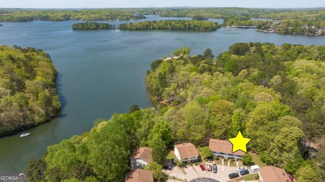 drone / aerial view featuring a water view and a forest view