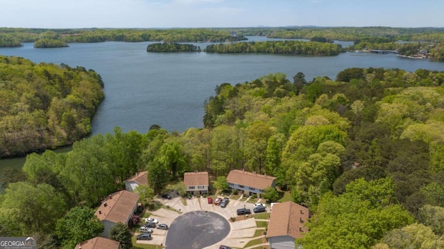 birds eye view of property with a water view and a wooded view