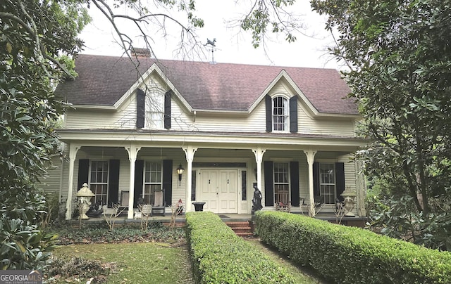 country-style home featuring a porch and a chimney
