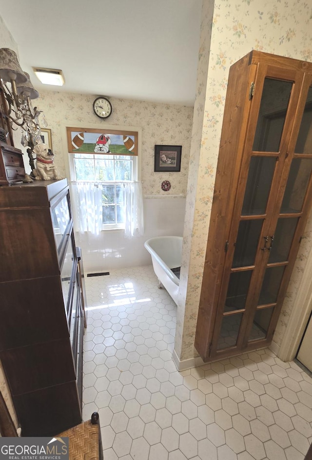 full bathroom featuring wallpapered walls, a soaking tub, and tile patterned flooring