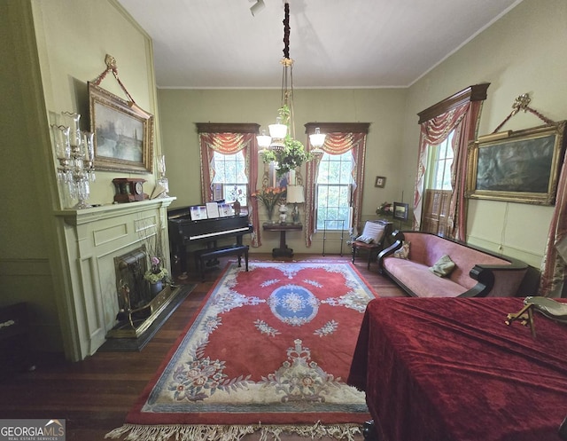 sitting room with plenty of natural light, ornamental molding, and wood finished floors