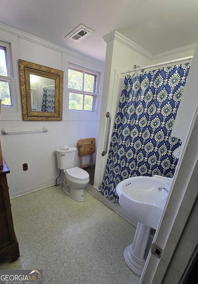 bathroom featuring toilet, a shower with shower curtain, baseboards, visible vents, and ornamental molding