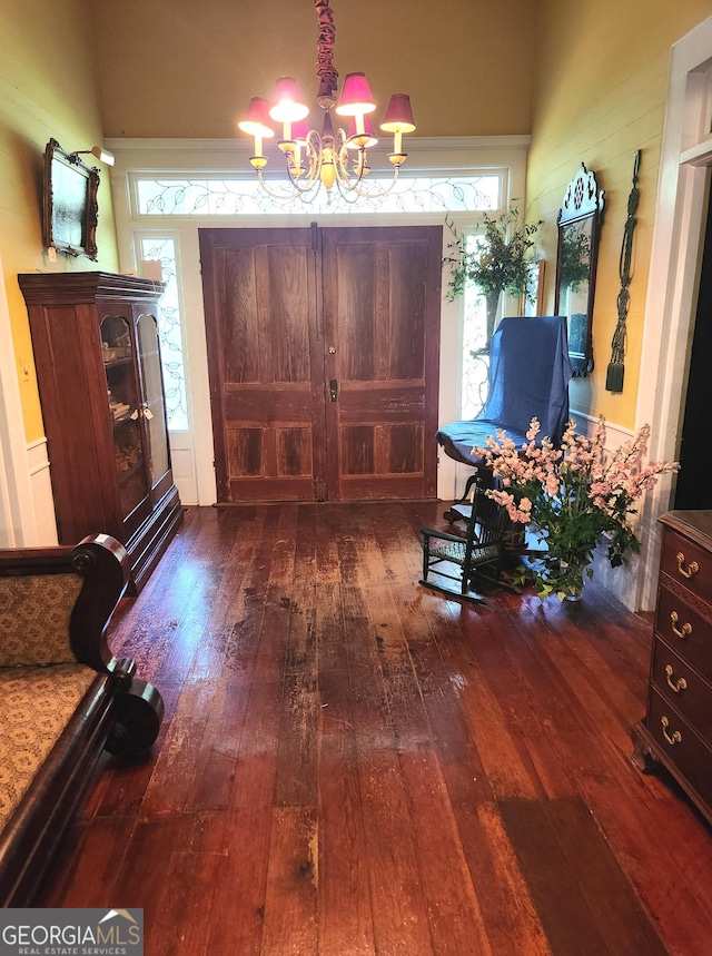 foyer featuring wood-type flooring and an inviting chandelier
