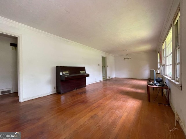 2988 Ramble Ln, Decatur, GA 30033 - unfurnished living room featuring visible vents, wood finished floors, baseboards, an inviting chandelier, and ornamental molding