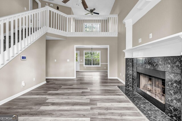 60 Whispering Pine Ct, Covington, GA 30016 - unfurnished living room with a ceiling fan, wood finished floors, a fireplace, high vaulted ceiling, and baseboards