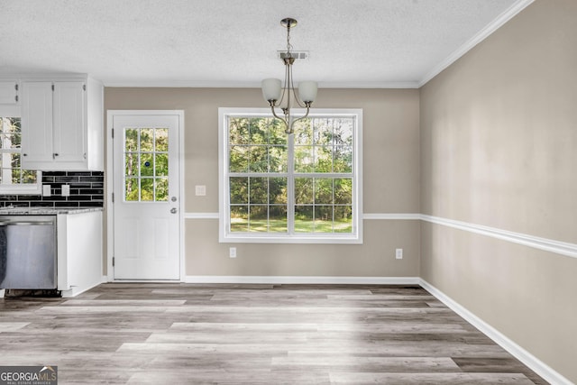 60 Whispering Pine Ct, Covington, GA 30016 - unfurnished dining area featuring healthy amount of natural light, a textured ceiling, light wood-style flooring, a chandelier, and baseboards